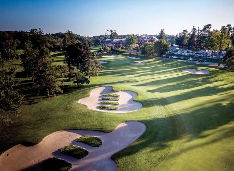 An aerial view of a golf course in Hamilton, surrounded by trees at a Country Club.