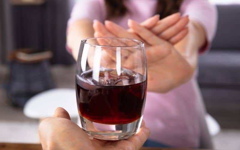 Woman's Hand Refusing Glass Of Drink