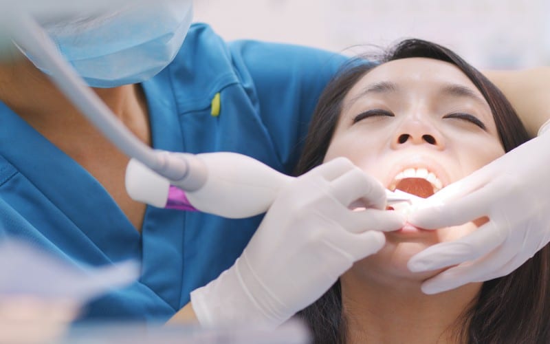 woman doing scaling root planing dental clinic